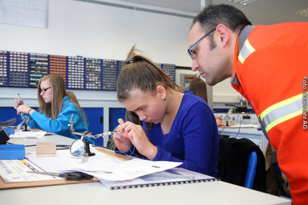 Janice Burgard (links) und Nina Meiser mit Ausbilder Recep Gülpinar hochkonzentriert bei der Arbeit in der Elektroabteilung.