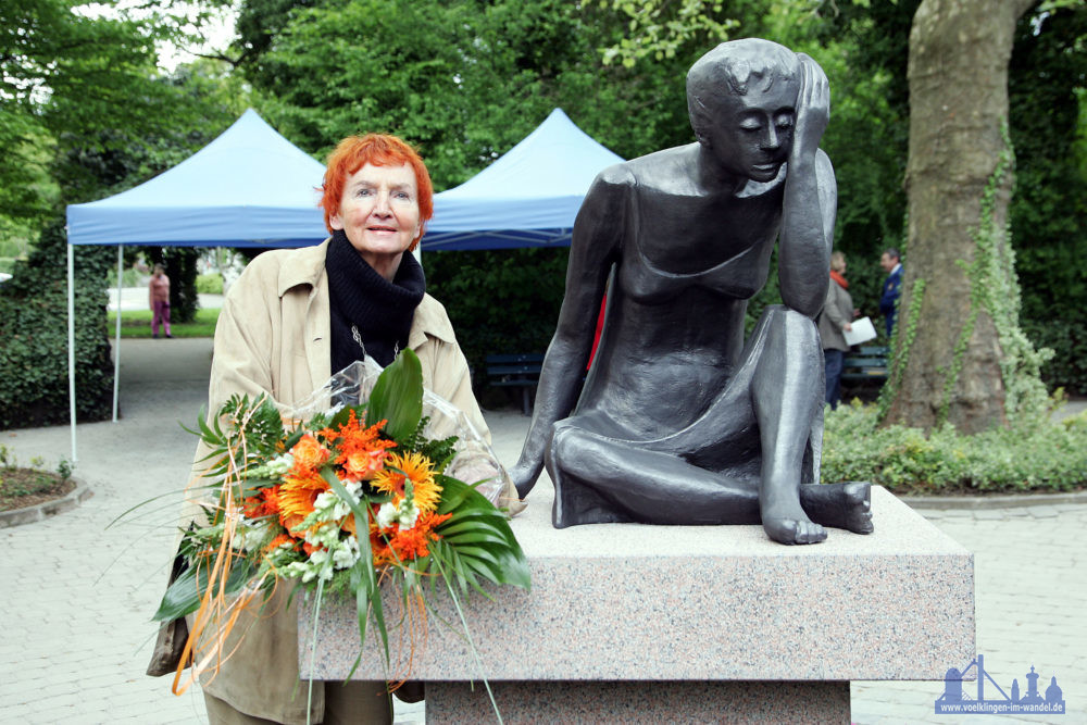 Inge Andler-Laurenzwurde am 2. April 1935 in der Hüttenstadt geboren, das Foto zeigt sie neben der Skulptur ´Weinende Mutter´ in den Kleinschen Anlagen (Foto: Stadt)