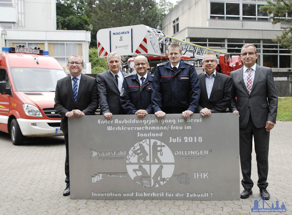 Norbert Moy, Schulleiter BBZ Völklingen,  Reiner Groß, Referatsleiter im Ministerium für Bildung und Kultur Frank Minor, Leiter der Werkfeuerwehr Dillinger Michael Dörr, Leiter der Werkfeuerwehr Saarstahl Völklingen Cornelis Wendler, Leiter Aus- und Weiterbildung Saarstahl und Dillinger Patrick Philippi, Leiter Sicherheit und Gesundheit Saarstahl und Dillinger  mit einer eigens angefertigten Stahlplatte zum neuen Ausbildungsberuf „Werkfeuerwehrmann/-frau“, die im BBZ einen Platz finden wird. (Foto: SHS)