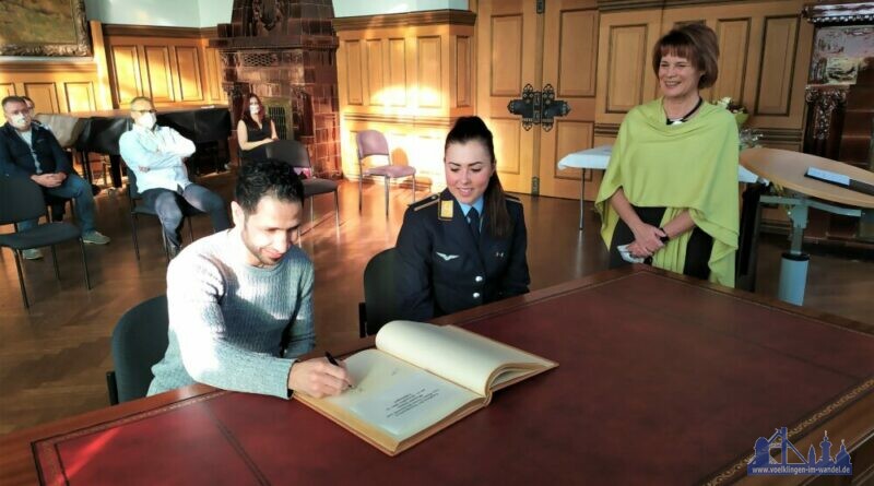 Lisa Klein und Wessam Salamana tragen sich in das Goldene Buch der Stadt Völklingen ein. Quelle: Stadt Völklingen / Anne Bartelt