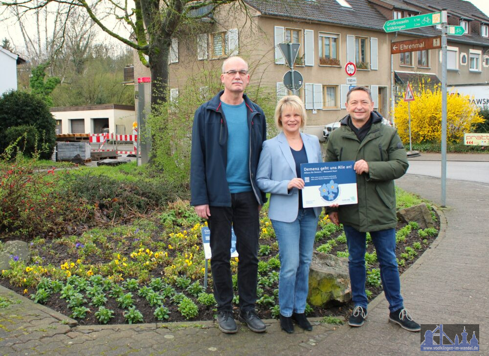 V.l.n.r.: Harald Steinberger (Öffentliches Grün und Friedhöfe, Stadt Völklingen), Oberbürgermeisterin Christiane Blatt und Andreas Sauder, Leiter der Landesfachstelle Demenz, vor dem Blumenbeet am Dorfkreuz in Geislautern. (Bild: Stadt VK)
