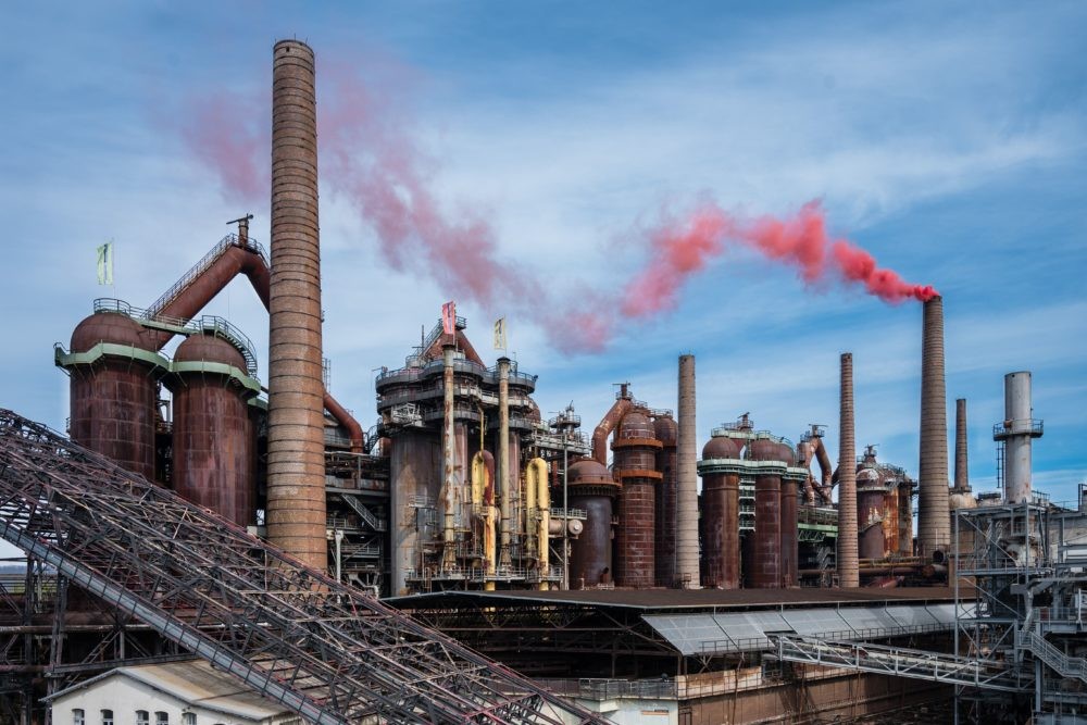 Aus einem Schornstein des Weltkulturerbes Völklinger Hütte steigt am 06.04.2019 roter Qualm auf. Dies war die Generalprobe für die Saisoneröffnung und Eröffnung der 5. Urban Art Biennale am kommenden Sonntag, bei der der spanische Urban Art-Künstler SpY mittels Pyrotechnik die Völklingen Hütte noch einmal rauchen lassen wird. Foto: Oliver Dietze/WKE