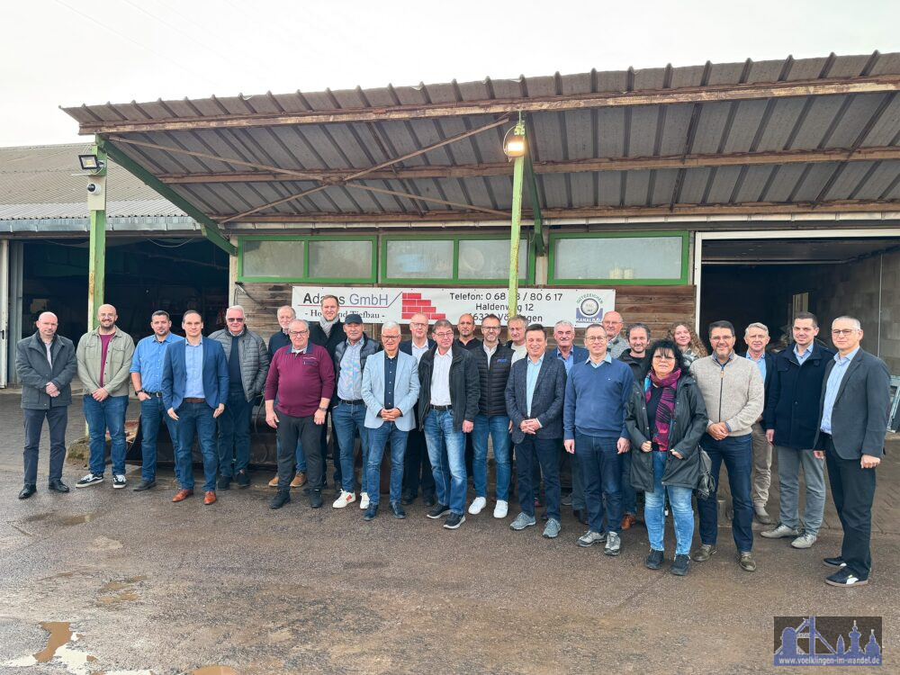 Oberbürgermeister Stephan Tautz (1. Reihe Mitte) und Gastgeber Reinhold Adams (1. Reihe roter Pullover) mit den Teilnehmerinnen und Teilnehmern des Völklinger Unternehmerdialog im November 2025.Bild: Stadt Völklingen 