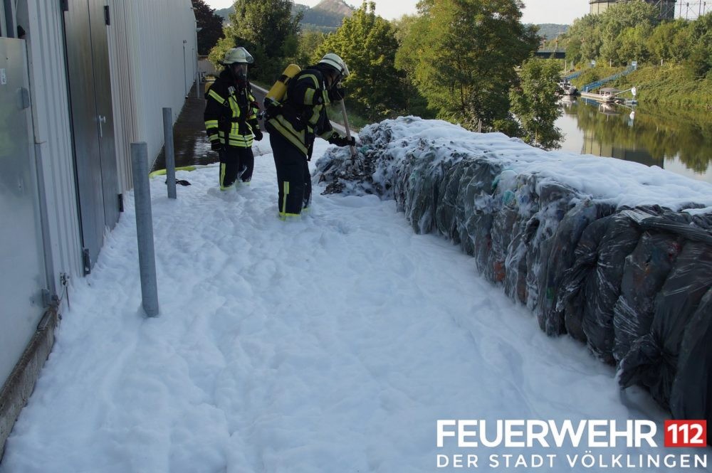 An einem Warenhaus kam es zum Brand von mehreren Säcken mit gepressten Pfandflaschen, die in unmittelbarer Nähe zum Gebäude gelagert wurden. Die Einsatzkräfte löschten das Feuer mittels Schaum ab und kontrollierten das Innere des Gebäudes. Am Außenbereich musste ein Teil der Metallverkleidung wegen aufgestauter Hitze geöffnet werden. Nach Kühlen dieses Bereiches wurde die Einsatzstelle an den Betreiber übergeben. Bildbeschreibung und Foto: Feuerwehr Völklingen