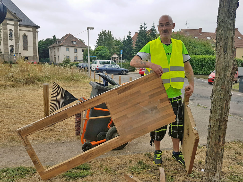 Hans Jürgen Schmitt begutachtet eine entsorgte Arbeitsplatte: "Sperrmüll können wir mit unserem Müllwägelchen leider nicht mitnehmen!". Etwas versteckt sein "Lamborghini". (Foto: Hell)