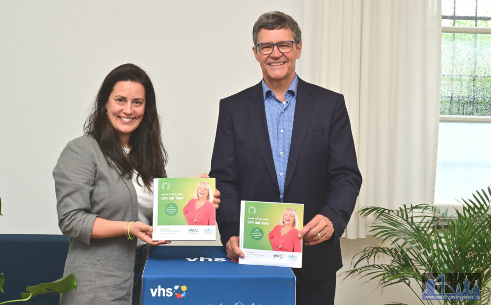 Regionalverbandsdirektor Peter Gillo und vhs-Direktorin Dr. Carolin Lehberger halten das neue Semesterprogramm in Händen. Foto: Stephan Hett/Regionalverband Saarbrücken.